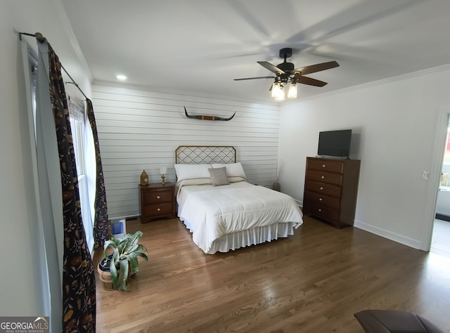 bedroom with crown molding, ceiling fan, and dark hardwood / wood-style floors