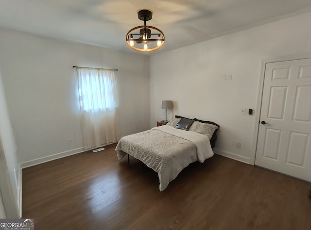 bedroom with dark wood-type flooring