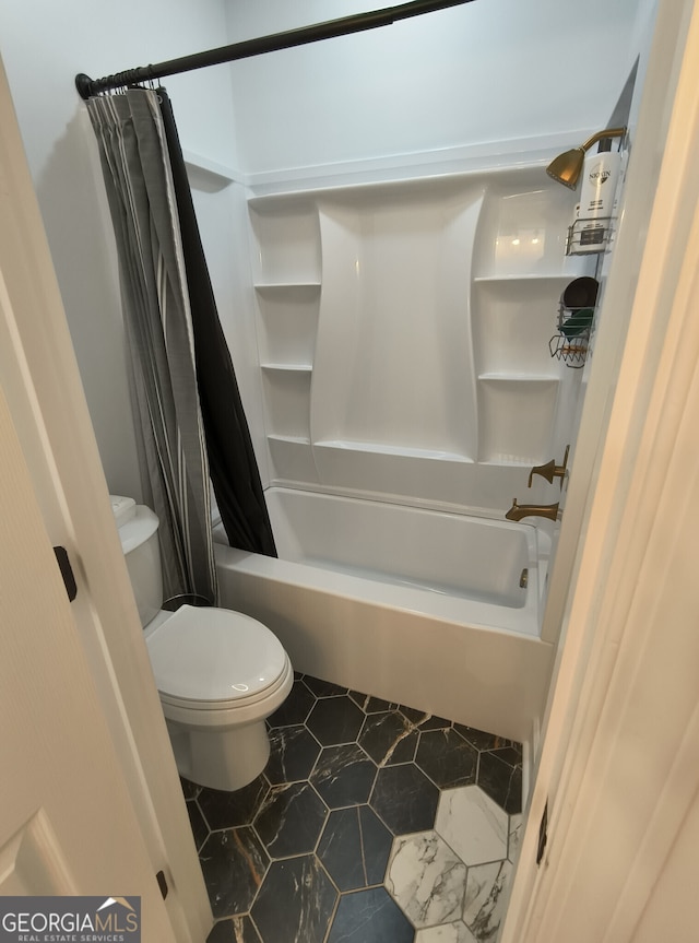 bathroom featuring shower / tub combo and toilet