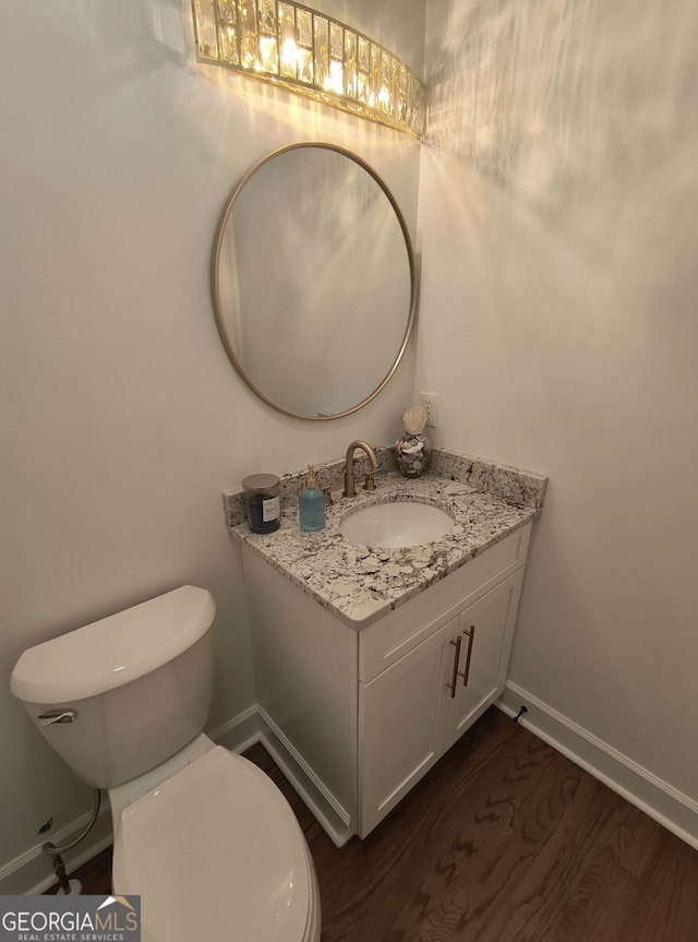 bathroom with vanity, toilet, and hardwood / wood-style floors