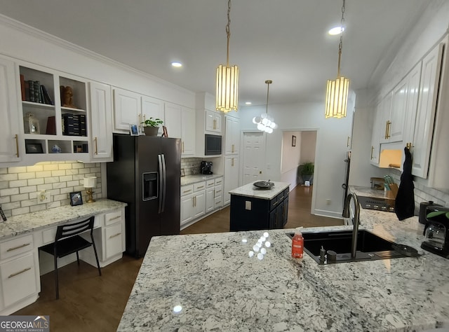 kitchen with hanging light fixtures, a kitchen island, white cabinets, and black appliances