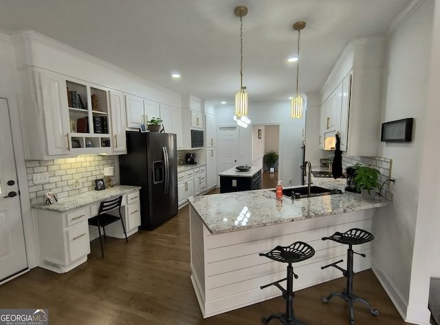 kitchen featuring white cabinetry, sink, hanging light fixtures, black appliances, and light stone countertops