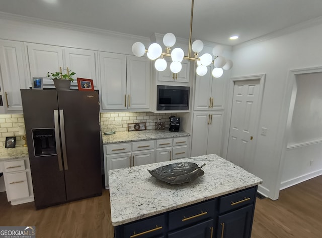 kitchen with built in microwave, stainless steel refrigerator with ice dispenser, a center island, and white cabinets