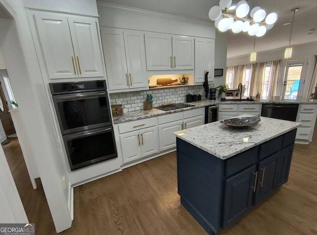 kitchen featuring kitchen peninsula, decorative light fixtures, sink, white cabinets, and black appliances