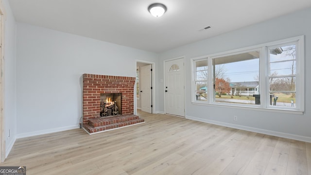 unfurnished living room featuring light hardwood / wood-style flooring and a fireplace