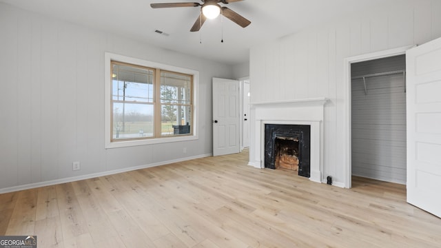 unfurnished living room featuring ceiling fan and light wood-type flooring