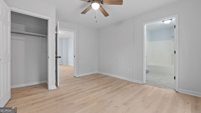 unfurnished bedroom with ensuite bathroom, a closet, ceiling fan, and light wood-type flooring