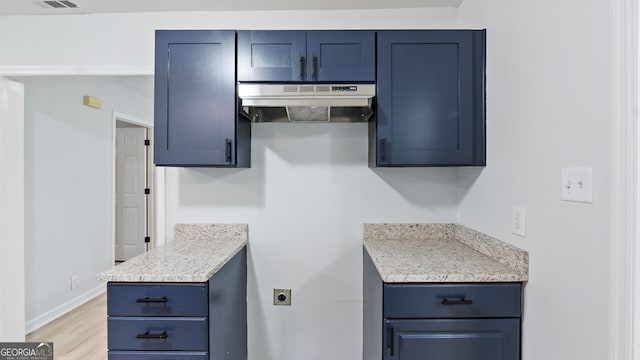 kitchen featuring blue cabinetry and light hardwood / wood-style floors