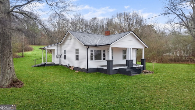 view of property exterior featuring a porch, a lawn, a chimney, and a shingled roof