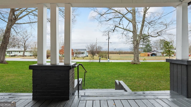 wooden deck featuring a lawn