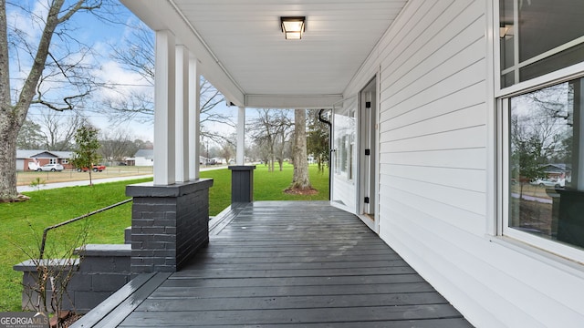 wooden terrace with a yard and covered porch