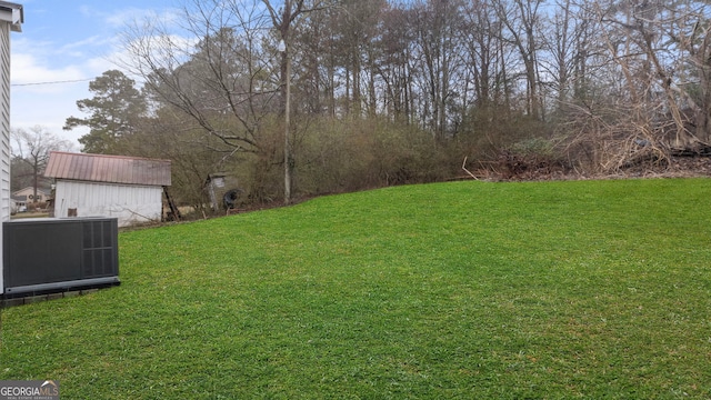 view of yard with central AC and a storage unit