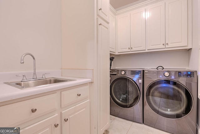 washroom with cabinets, washing machine and dryer, sink, and light tile patterned flooring