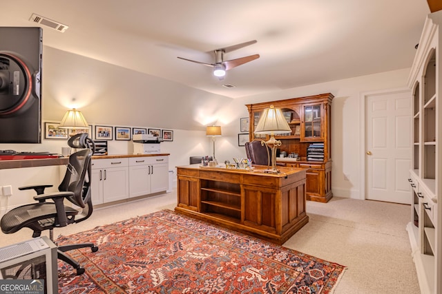 office space with ceiling fan, lofted ceiling, built in desk, and light carpet