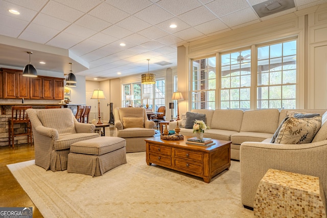 living room featuring a paneled ceiling and light hardwood / wood-style flooring