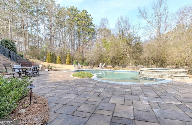 view of pool with a patio and an in ground hot tub