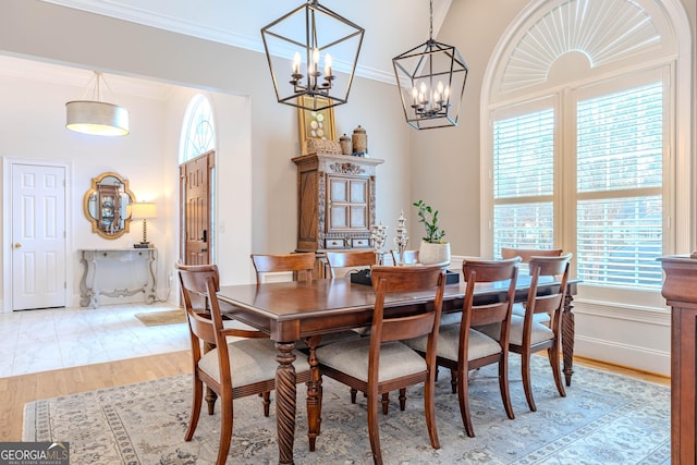 dining space with crown molding and light wood-type flooring