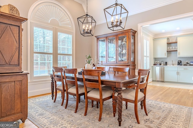 dining area with crown molding and light wood-type flooring