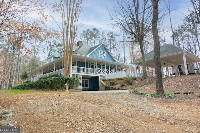 farmhouse inspired home with a porch and a carport