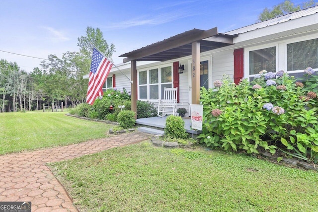 doorway to property with covered porch and a lawn