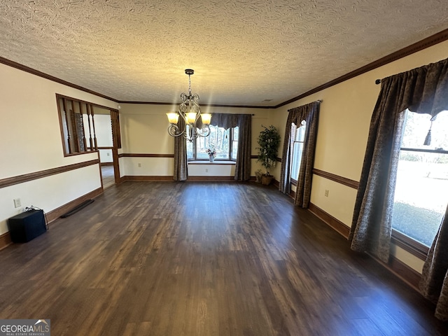 unfurnished dining area featuring crown molding, dark hardwood / wood-style floors, a textured ceiling, and an inviting chandelier