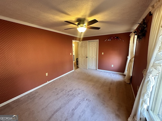 unfurnished bedroom featuring ceiling fan, ornamental molding, and a textured ceiling