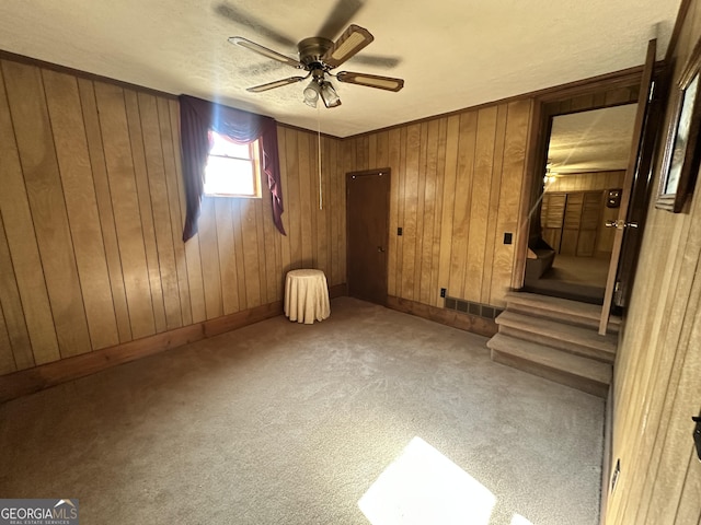 interior space featuring ceiling fan and wooden walls