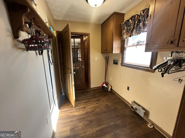 washroom with dark hardwood / wood-style flooring, cabinets, washer hookup, electric dryer hookup, and a textured ceiling