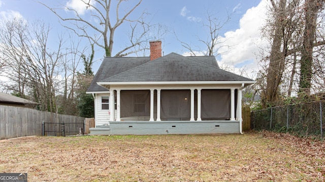 back of house featuring a sunroom and a yard