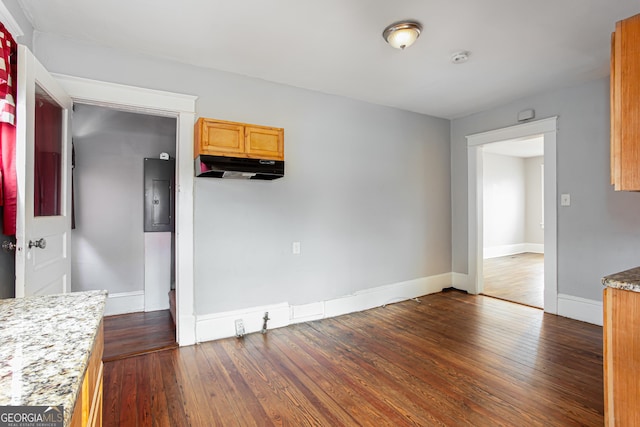 unfurnished dining area with electric panel and dark hardwood / wood-style floors