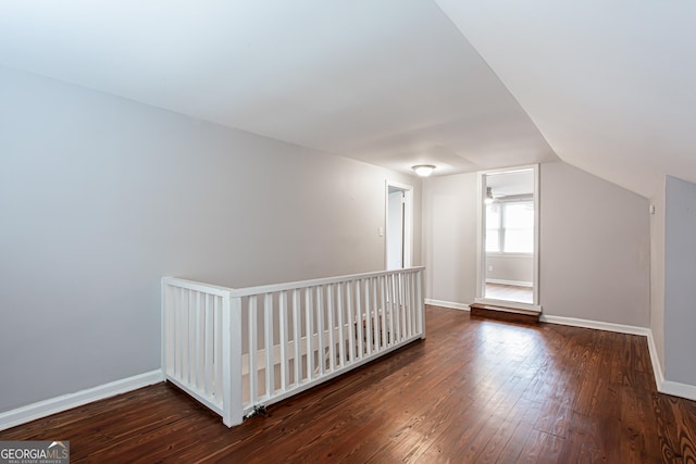 additional living space with dark wood-type flooring and vaulted ceiling