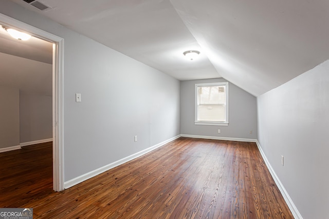 additional living space with lofted ceiling and dark hardwood / wood-style flooring