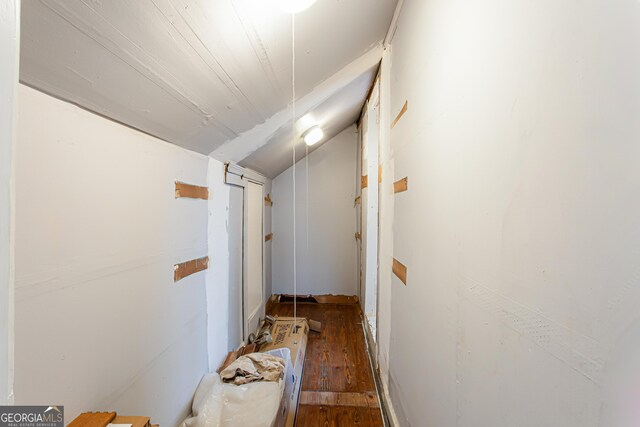 corridor featuring dark wood-type flooring and lofted ceiling