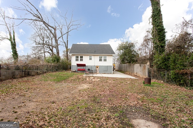 rear view of property featuring a hot tub and a patio area