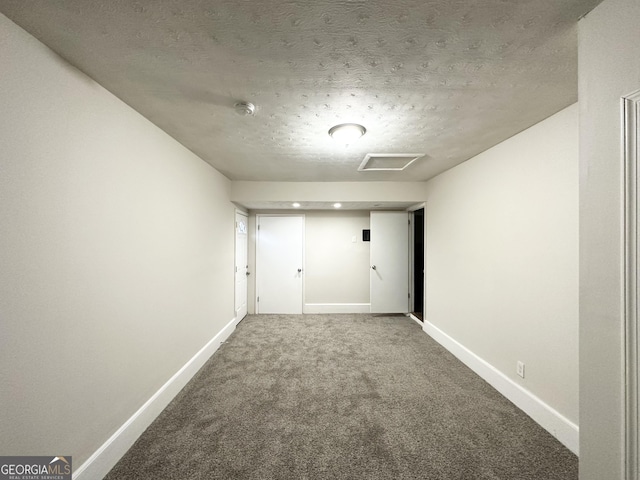 carpeted empty room featuring a textured ceiling