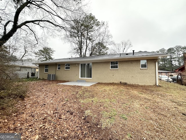 rear view of property featuring a patio, central AC unit, and a lawn