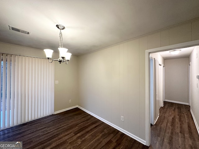 unfurnished dining area with an inviting chandelier and dark hardwood / wood-style floors