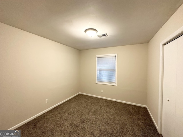 empty room featuring dark colored carpet