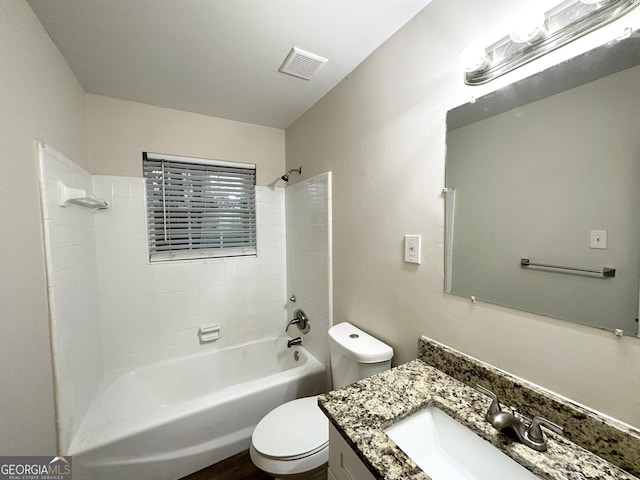 full bathroom featuring vanity, tiled shower / bath combo, and toilet