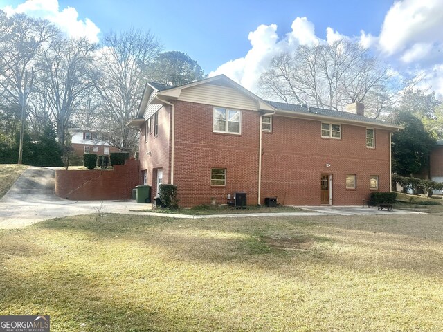 view of home's exterior with a garage, a yard, and cooling unit