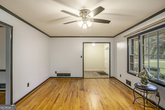 spare room with ornamental molding, ceiling fan, and light wood-type flooring