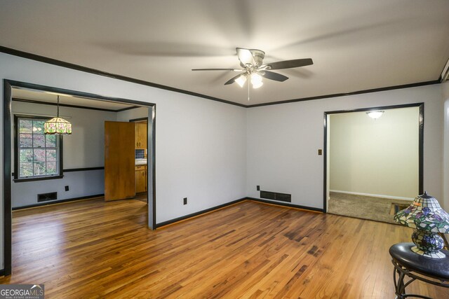 spare room featuring crown molding and hardwood / wood-style floors