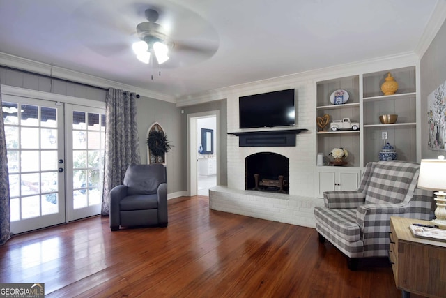 living area featuring french doors, a fireplace, ornamental molding, and dark hardwood / wood-style floors