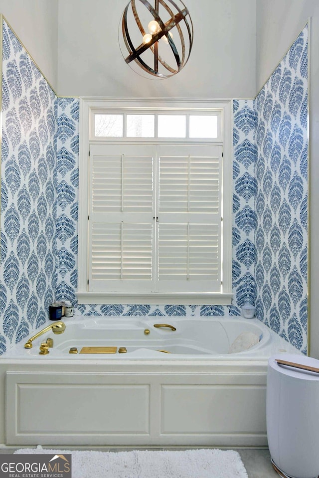 bathroom featuring plenty of natural light and a tub to relax in