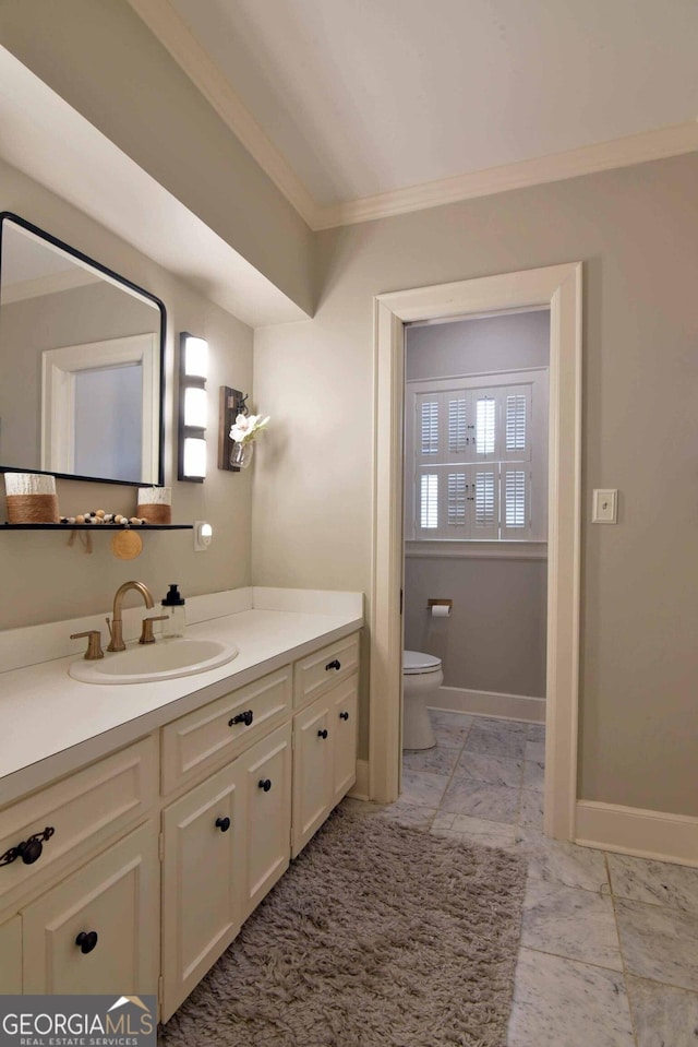 bathroom with ornamental molding, toilet, and vanity