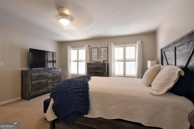 bedroom featuring multiple windows, light carpet, and ceiling fan