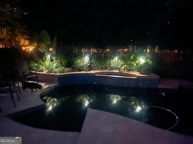 pool at twilight with a jacuzzi