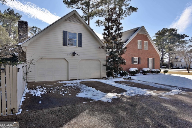 snow covered property with a garage