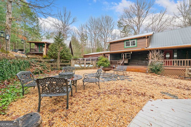 rear view of property with a deck and a fire pit