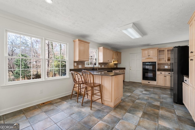 kitchen with a breakfast bar area, stainless steel fridge, black double oven, decorative backsplash, and kitchen peninsula